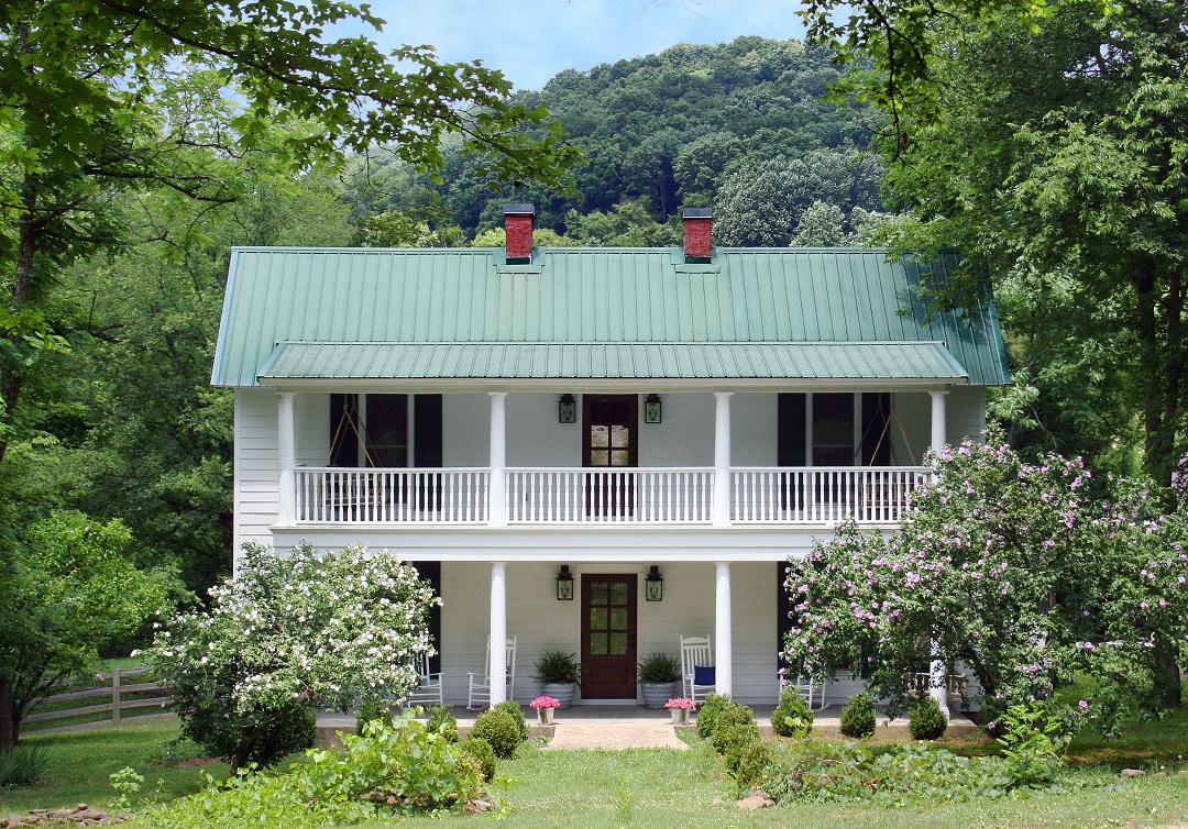 Artic-White-Farmhouse-In-HardiePlank-Fiber-Cement-Lap-Siding-With-Lilac-Bushes-And-Lush-Green-Garden-Walkway