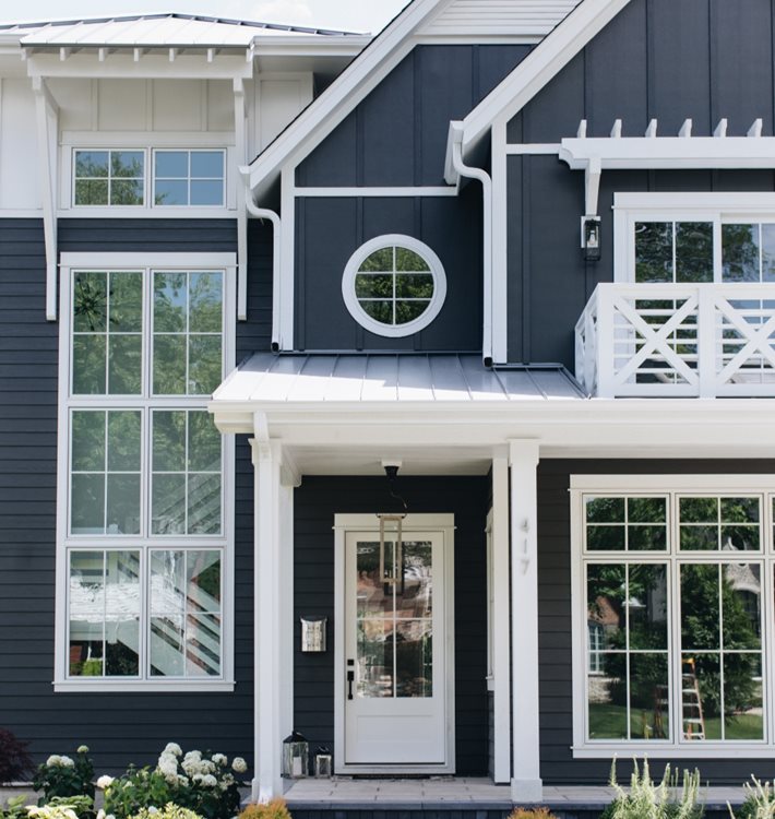 A dark blue and white house with batten board siding and lap siding for a slightly nautical style.