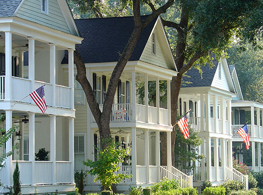 Cream-Colored-Two-Story-Colonial-Houses-Surrounded-By-Tall-Green-Trees