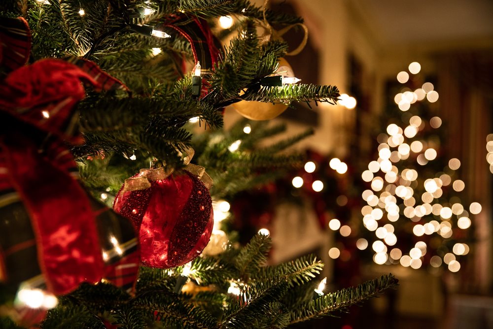 Christmas lights and wreath outside of a house porch.