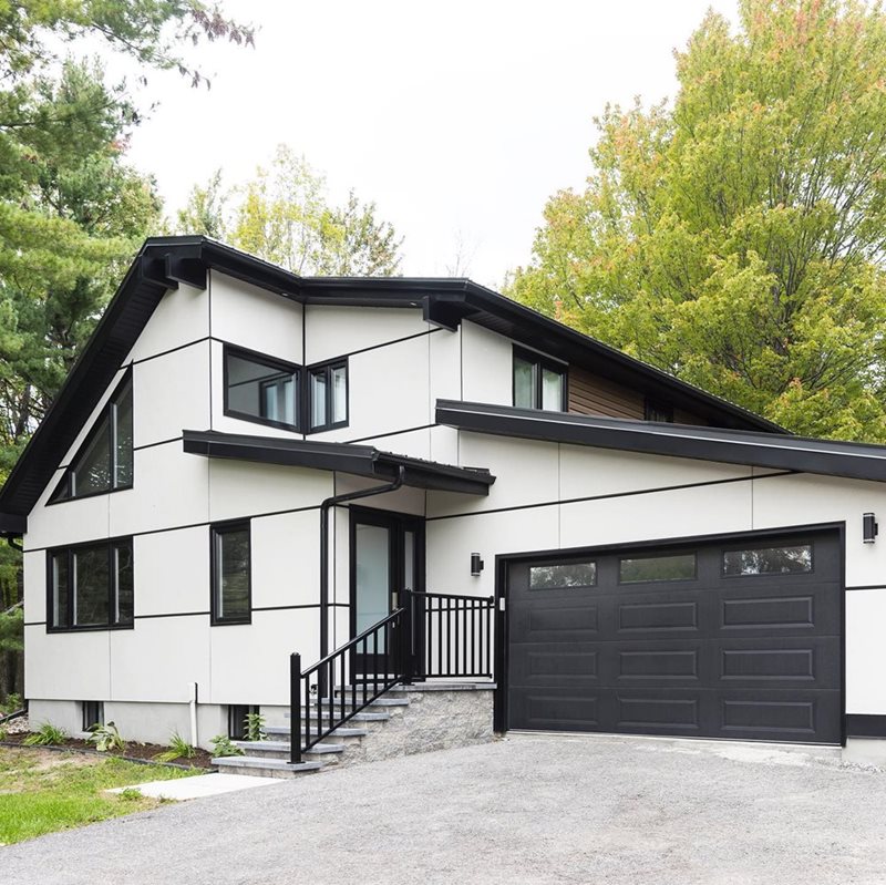 An outside house design that features a modern look with panel siding.