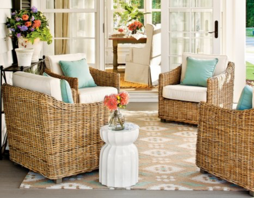 Bright-Sun-Room-Including-Brown-Woven-Chairs-With-Light-Blue-And-White-Pillows-White-Pedestal-Holding-Red-Flowers-In-Clear-Vase